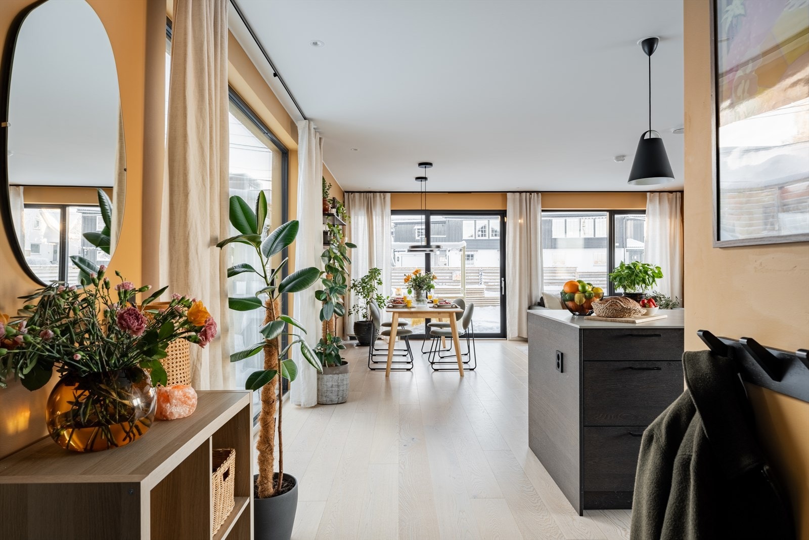 Velkommen inn til en stilren entré med flislagt gulv, varme farger og god plass til garderobe. Videre åpner rommet seg mot kjøkken og stue, med 1-stavs eikeparkett og store vinduer som fyller etasjen med dagslys. Det er varmekabler i entré. Galleribilde