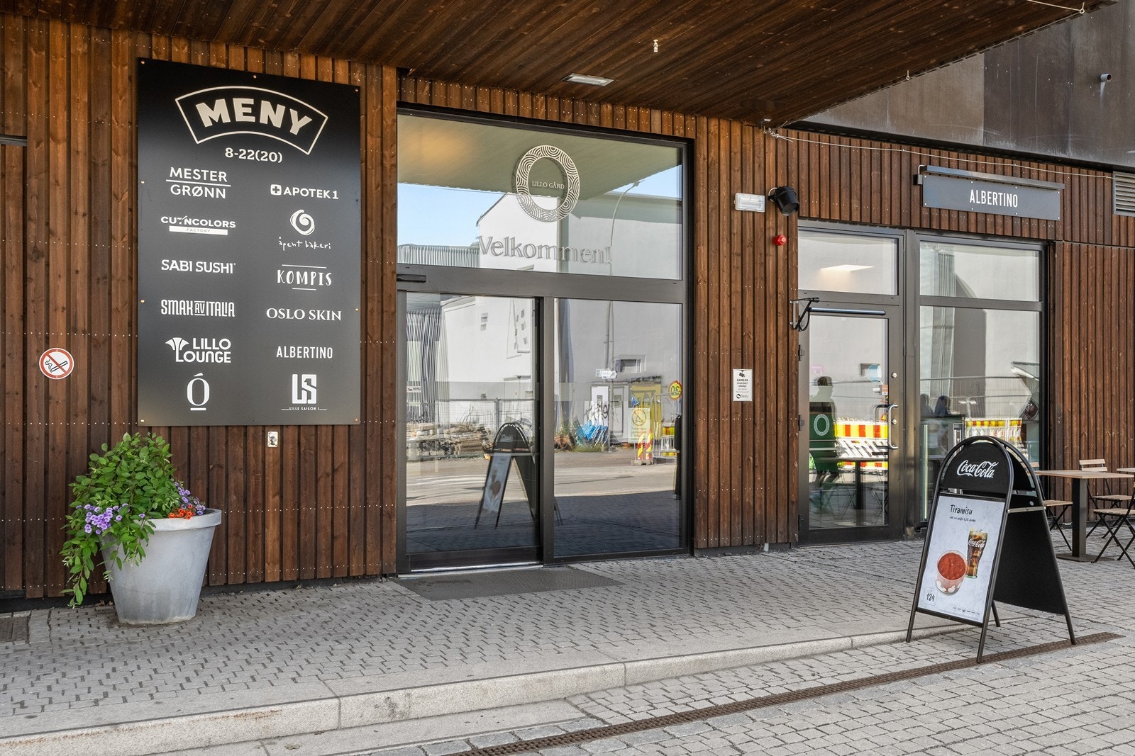 Nye Lillo Gård ligger rett over gaten og er et moderne og attraktivt handlesenter med blant annet Meny, blomsterforretning og spesialbutikker som Smak av Italia. Galleribilde