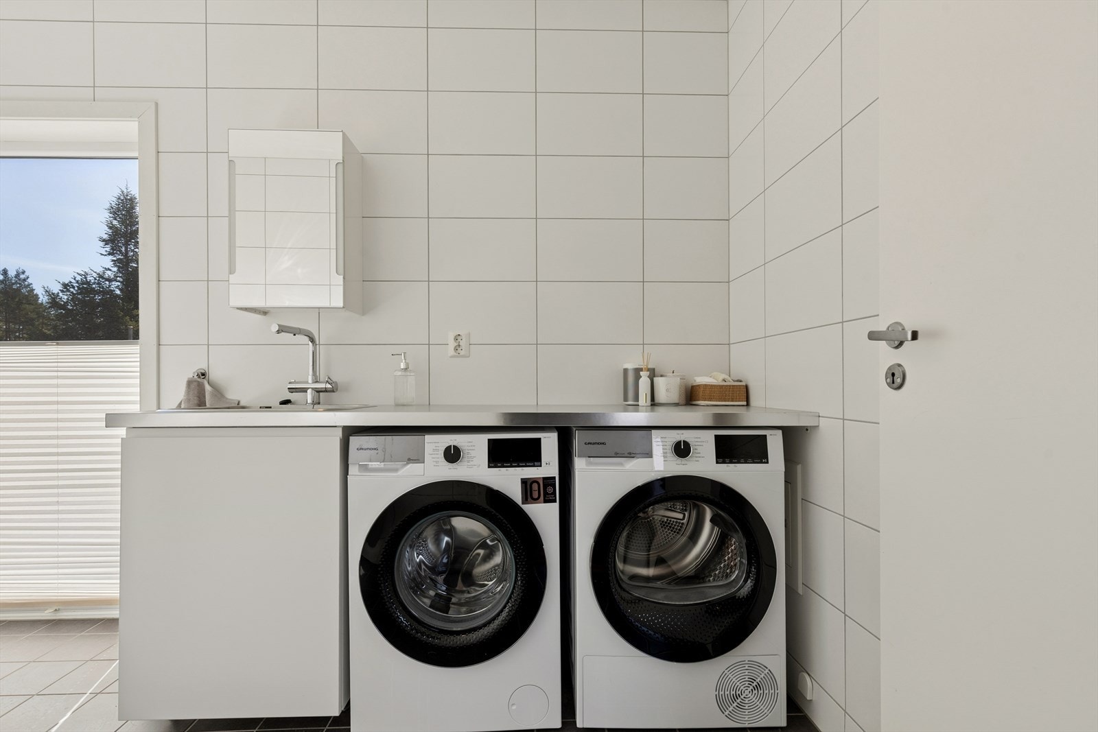 Badet har en praktisk utslagsvask og det er plass til både vaskemaskin og tørketrommel. Den praktiske hyllen over passer utmerket for å brette klær. Galleribilde