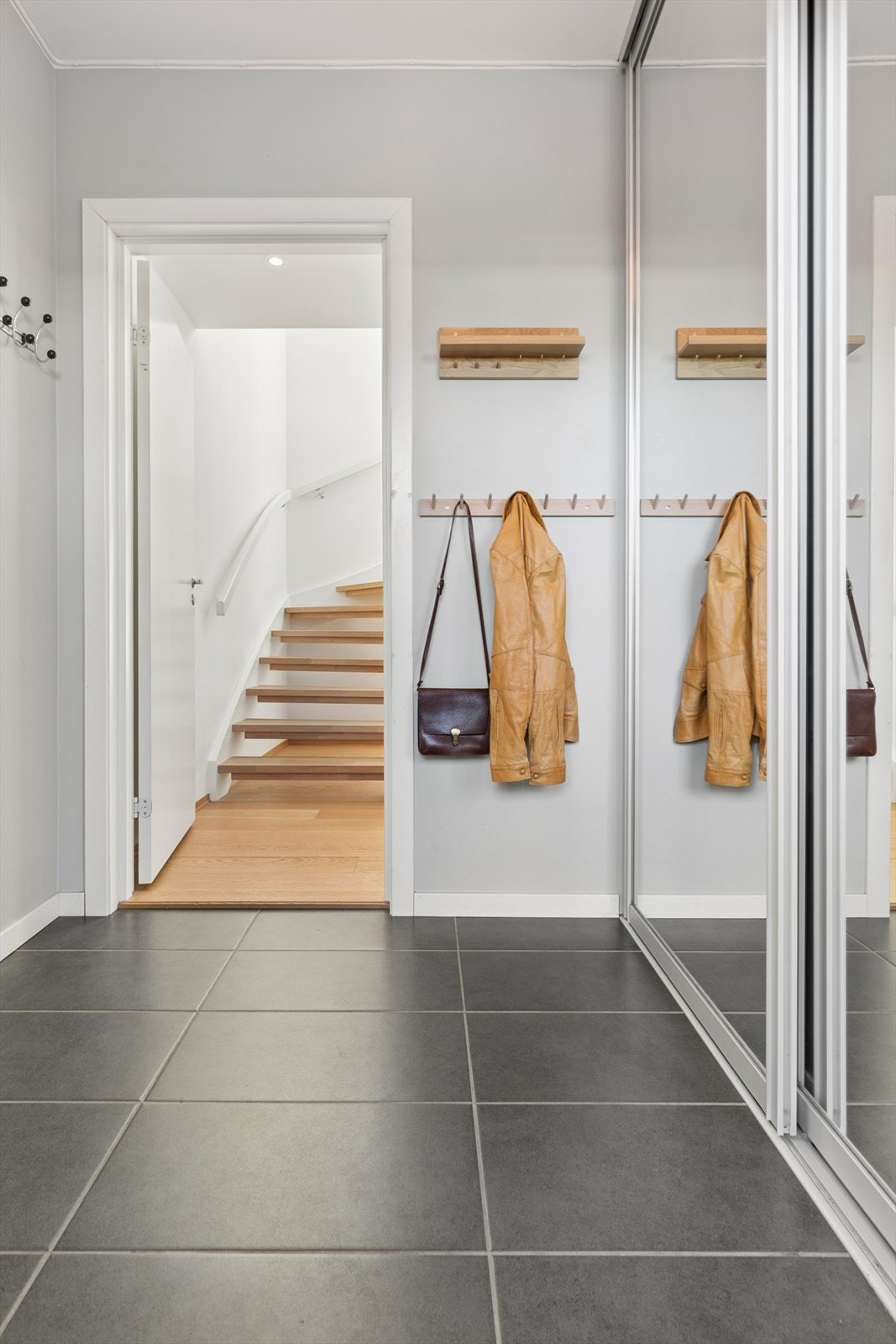 I gangen er det flislagt gulv med varmekabler og en stor skyvedørsgarderobe. Her finner du også inngangen til den integrerte dobbeltgarasjen. Galleribilde