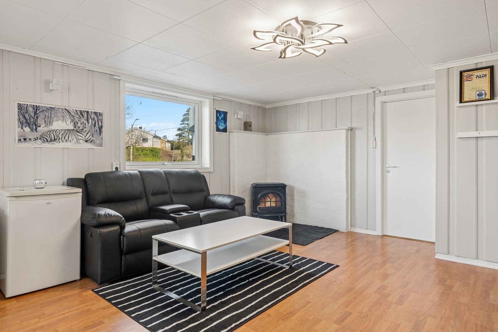 Også kjellerstuen har et ildsted som bidrar med varme og hygge. Kjellerstuen er innredet i areal godkjent som disponibelt rom. Se pkt. ferdigattest i salgsoppgaven. Galleribilde