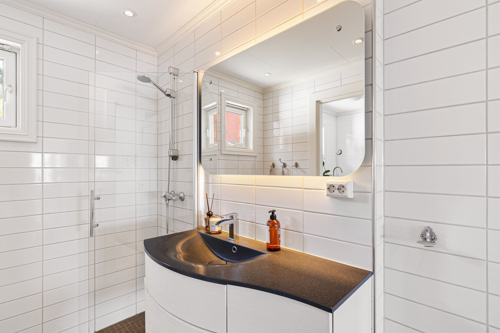 Badet har et moderne uttrykk og er på ca. 4.5m². Her finner du vegghengt toalett, servantskap og innfellbar dusjvegg. Galleribilde