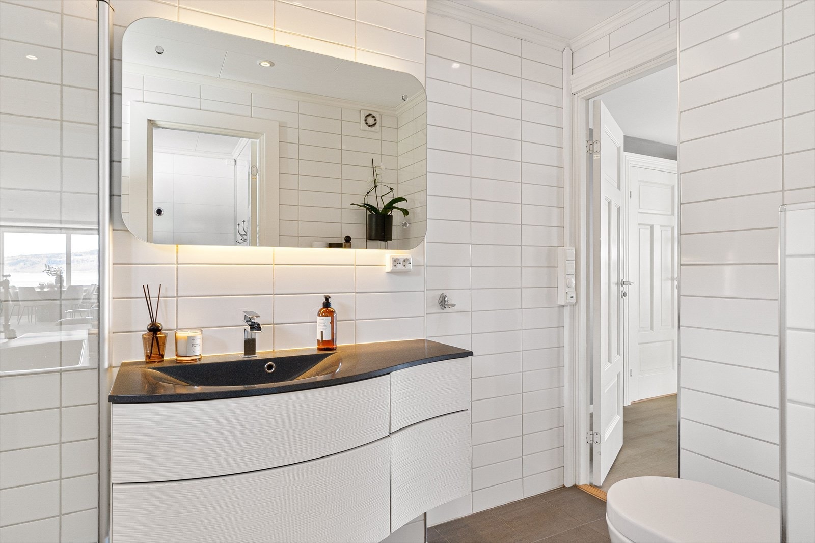 Det flislagte badet har elektrisk gulvvarme, downlights i himling og lysspeil. Galleribilde