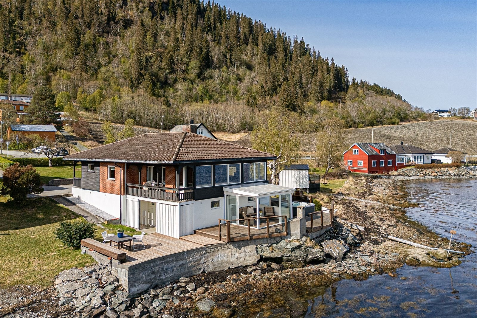 Eneboligen har en romslig garasje, elbilader og steinbelagt gårdsplass. Galleribilde