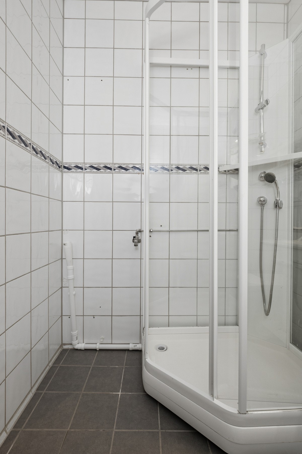 Baderomsinnredningen har hvite, glatte fronter og består av en heldekkende servant på en skapseksjon, to veggskap og et speil med belysning Galleribilde