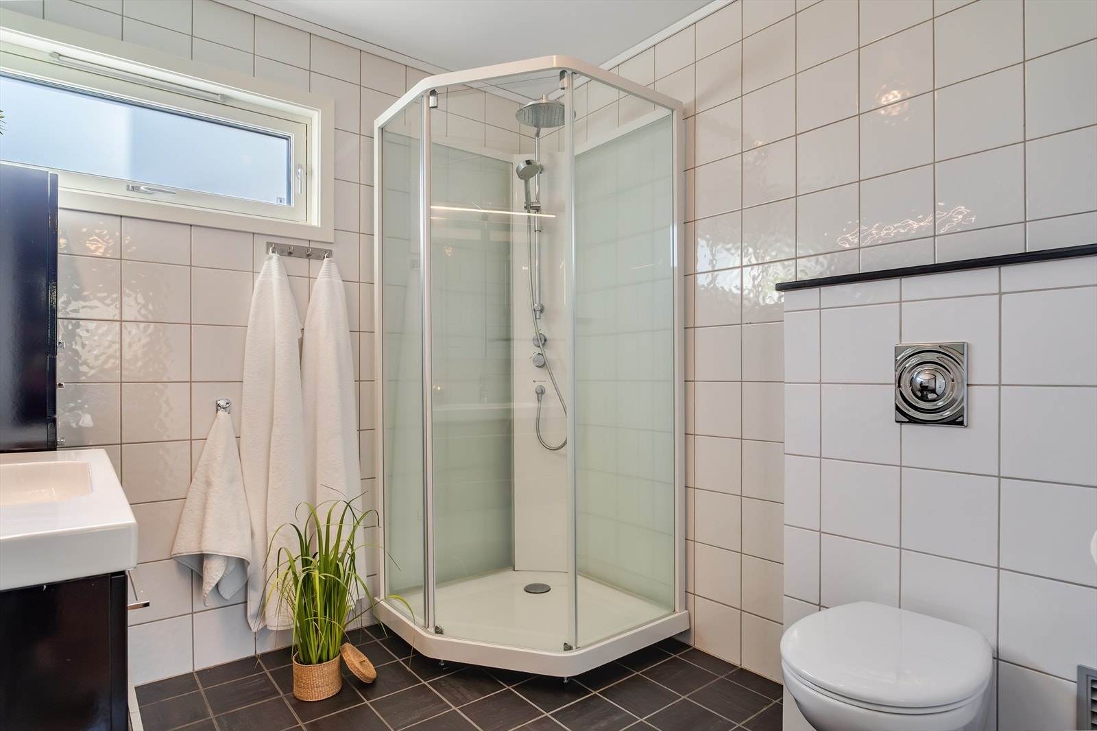 Inneholder dusjkabinett, vegghengt toalett, innredning m/servant, sideskap og overskap m/speil. Galleribilde