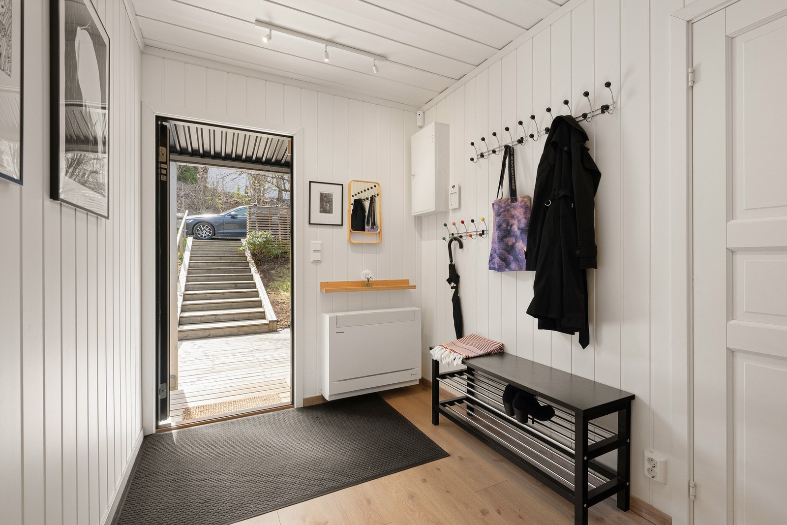 Lys og innbydende entré med oppbevaringsmuligheter for yttertøy og sko Galleribilde