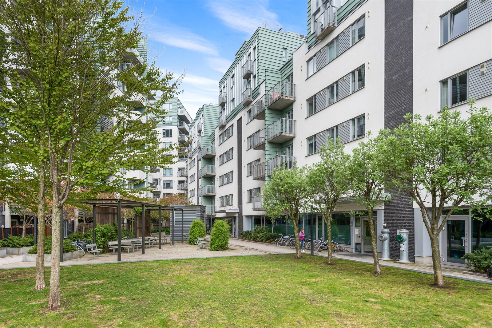 Bakgård med sittegrupper, lekeplass, gressplen og beplantning Galleribilde