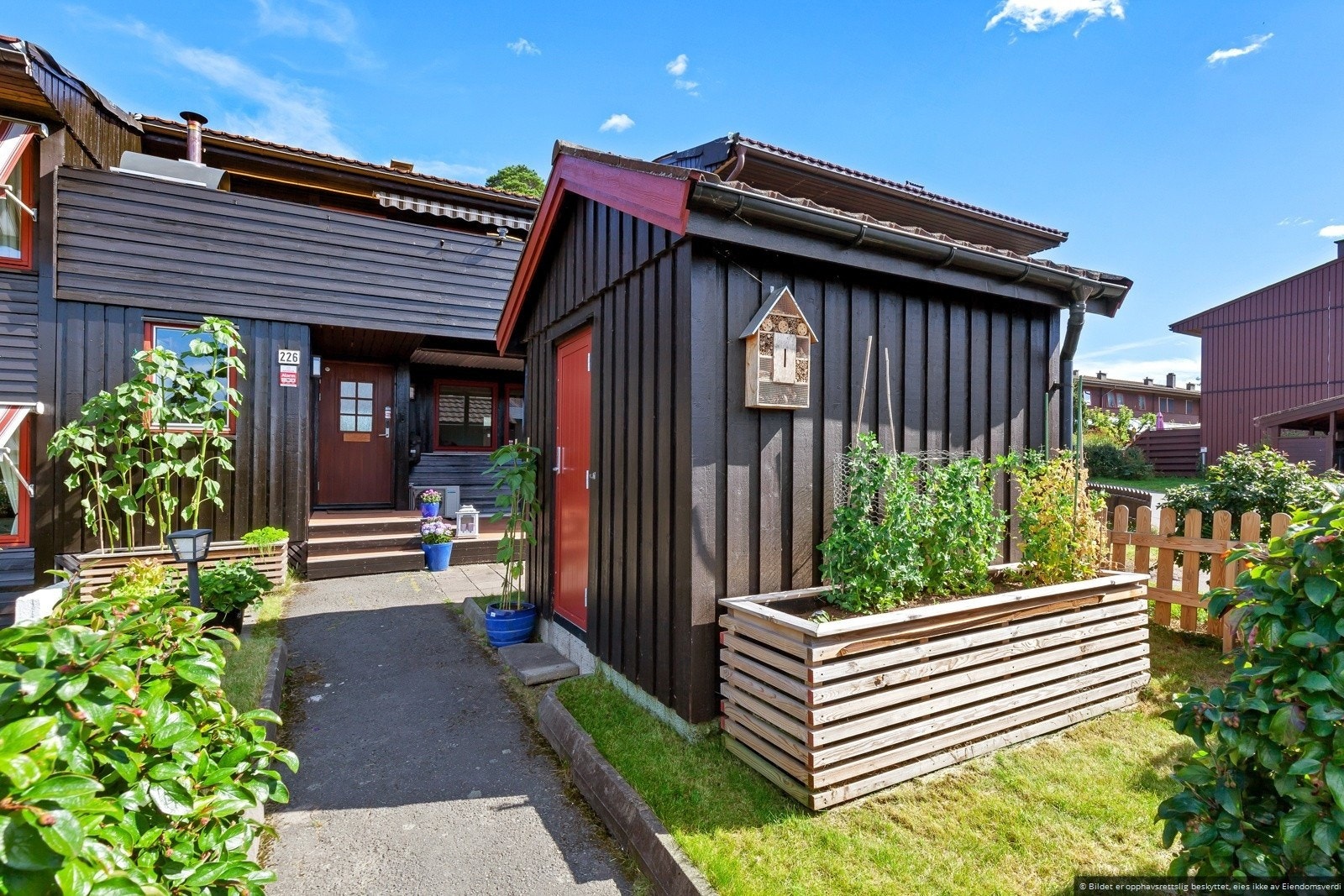 Et utrolig fint inngangsparti med beplaning, heller og terrasse. Galleribilde