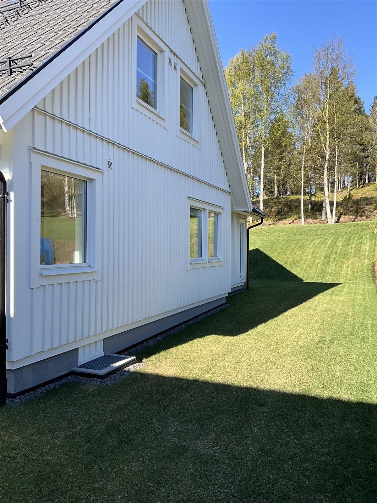 Nordside av enebolig. Stort areal med ferdigplen mot thujahekk/nabo Galleribilde