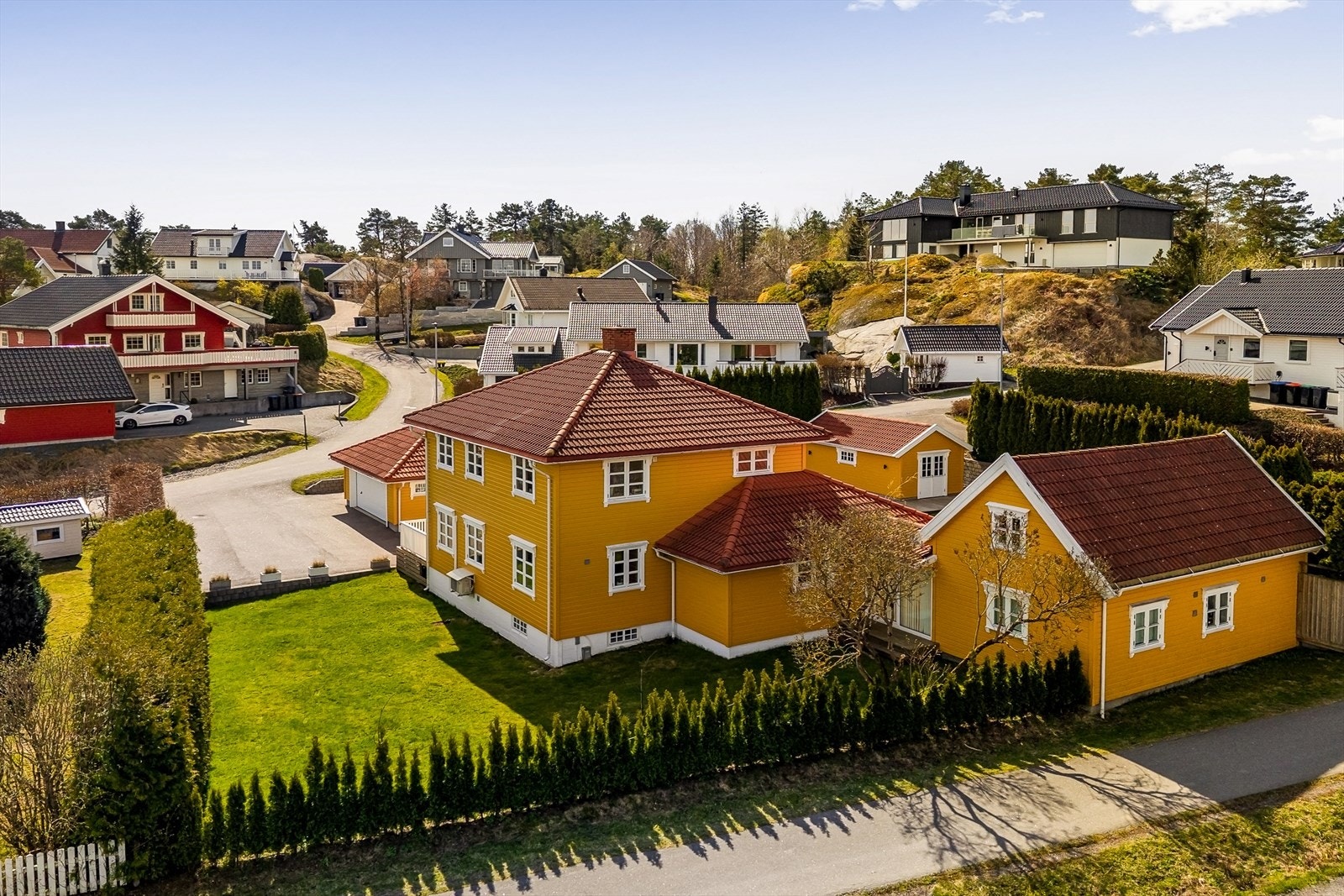 Romslig hovedhus med tilhørende sidebygning med fleksible bruksmuligheter. Hagen er innrammet av hekk, noe som gir et skjermet og privat preg. Fotograf: Karl Filip Kronstad Galleribilde