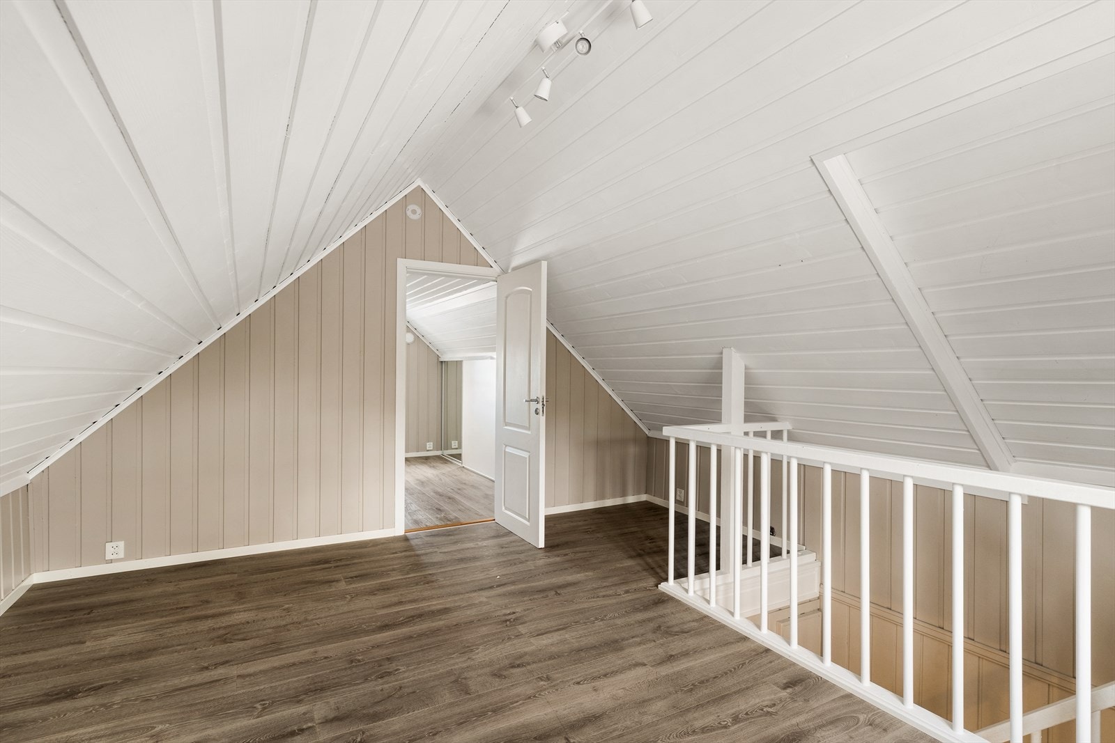 Skråtak på begge sider, som gir rommet karakter og en lun atmosfære. Rommet er åpent og uten fast innredning, noe som gjør det enkelt å tilpasse ulike bruksformål. Galleribilde