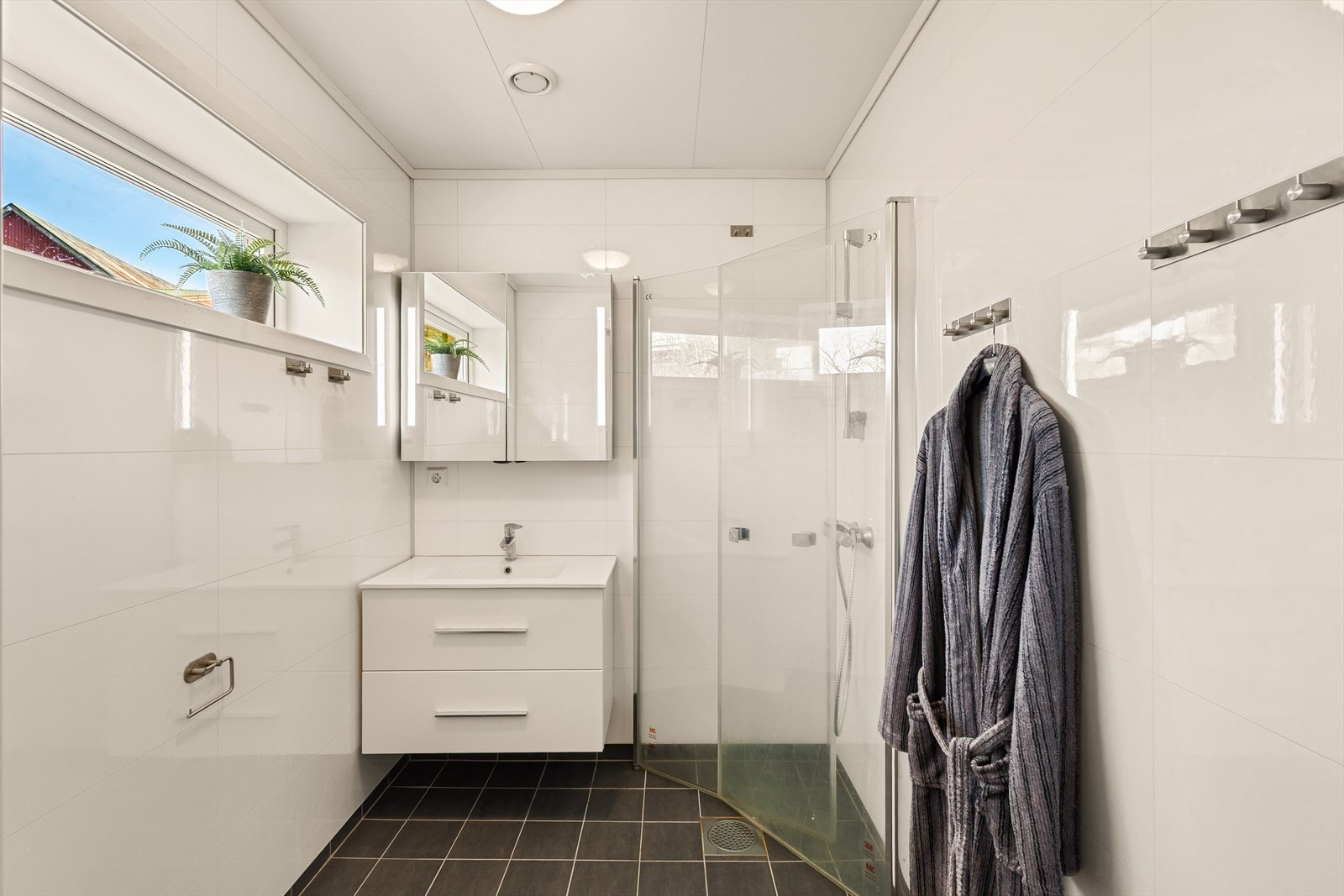 Bad med fliser på gulv og våtromsplater på vegger Galleribilde