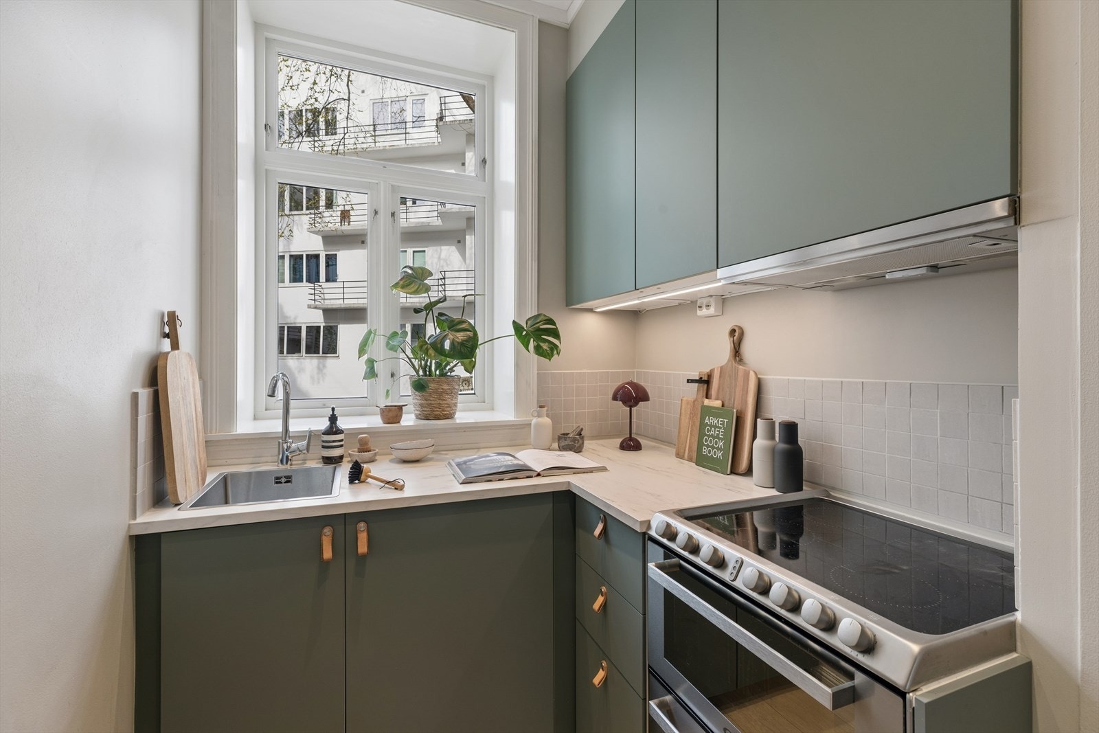 Her får du glatte, grønne fronter på skuffer og skap, samt laminat benkeplate. Hvitevarer består av kjøleskap, vannstoppsystem (ekstra sikkerhet ved lekkasje), komfyrvakt og opplegg for kombinert komfyr og oppvaskmaskin. Galleribilde