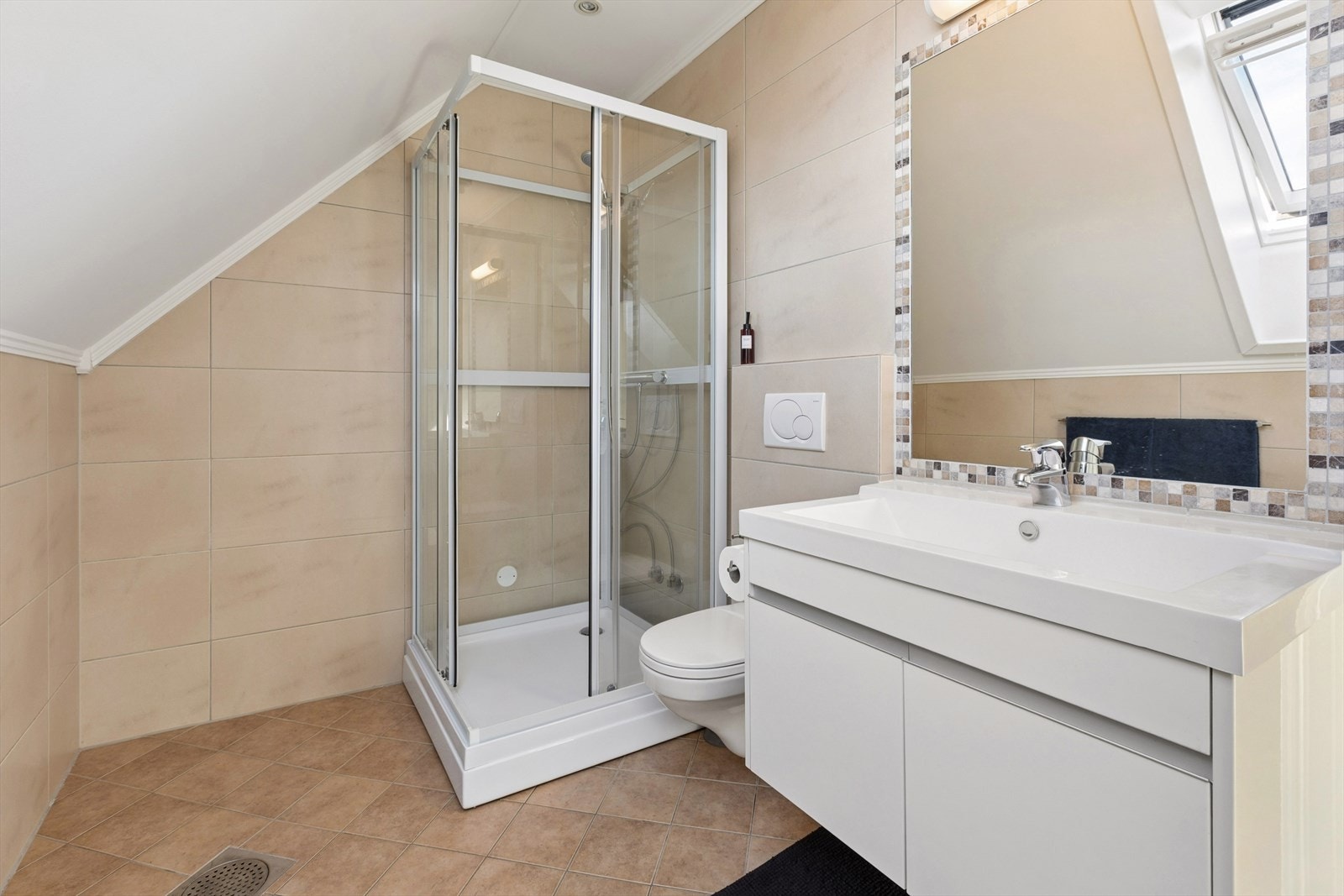 Badet i andre etasje har flislagt gulv med varmekabler, vegghengt toalett og dusjkabinett. Galleribilde