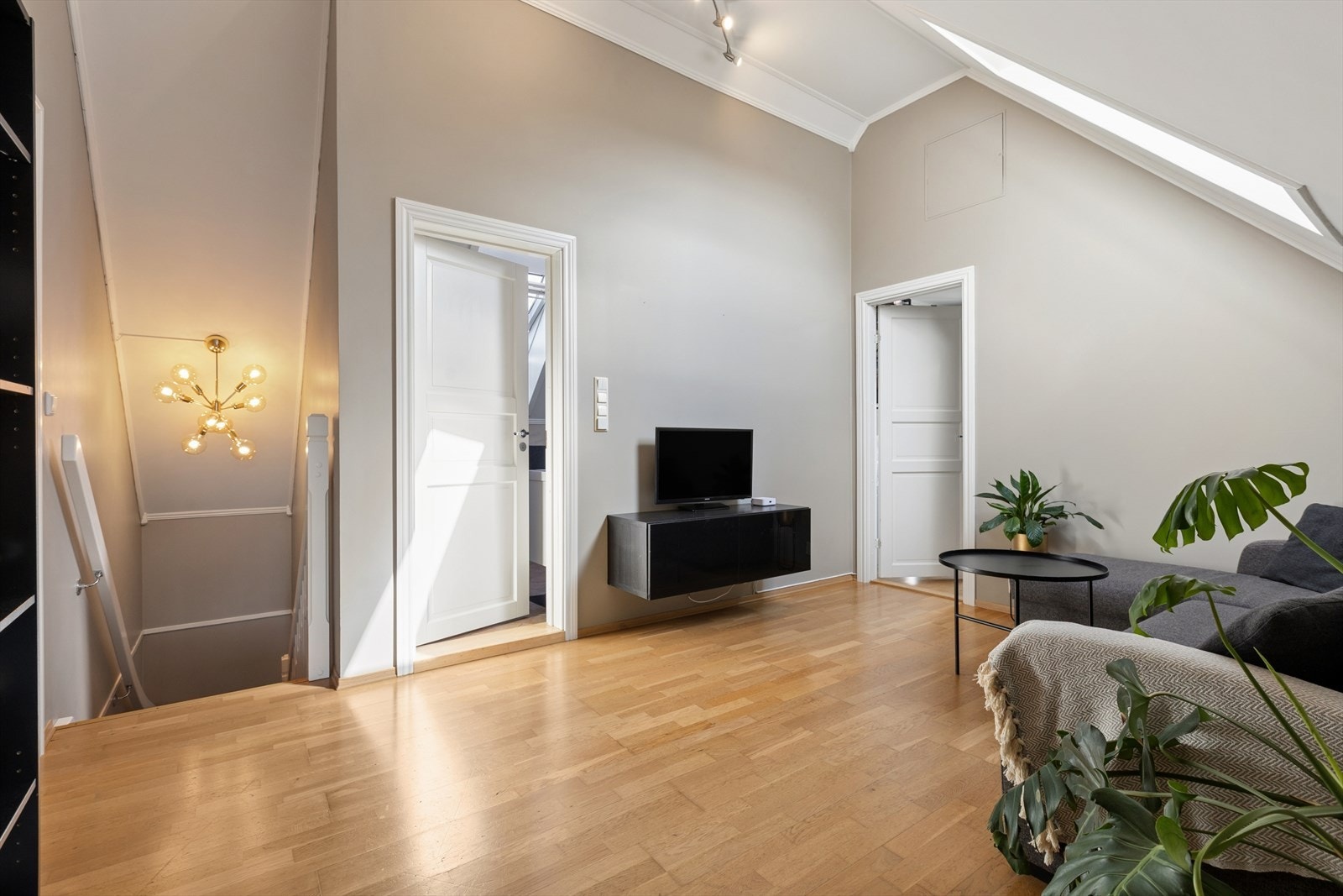 Vel oppe i loftsetasjen møtes du av et lyst allrom med en imponerende takhøyde på rundt 3,4 meter. Galleribilde