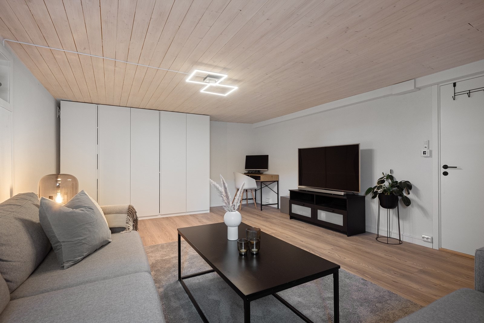 Rommet gir god plass til ulike møbleringsløsninger, med både sofagruppe og en egen kontorplass. Galleribilde