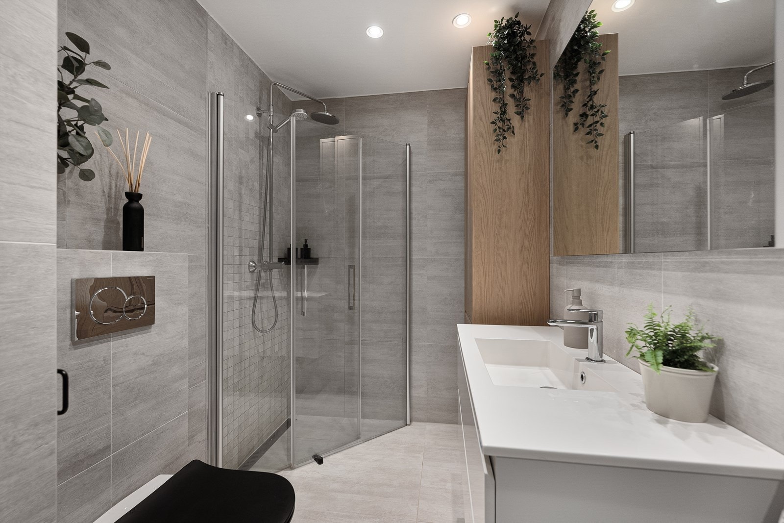 Badet er utstyrt med vegghengt toalett, servantinnredning og dusj med innfellbare glassdører. Håndkletørker ble montert i 2023. Galleribilde