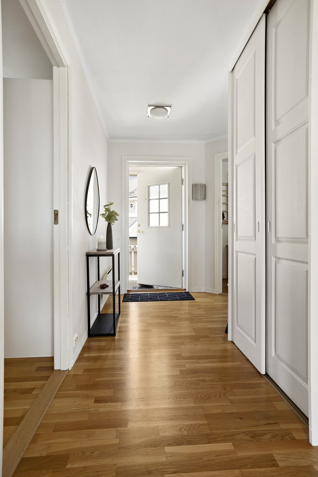 Romslig entré med en skyvedørsgarderobe for oppbevaring. Dør med glassfelt slipper lyset videre inn i stuen. Galleribilde