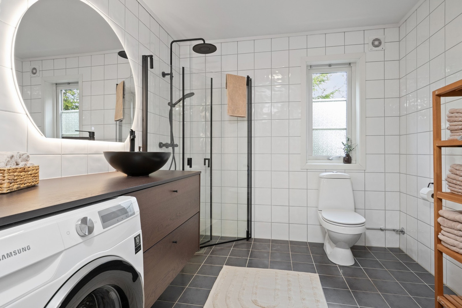 Badet er smakfullt innredet med grå gulvfliser og hvite veggfliser Galleribilde