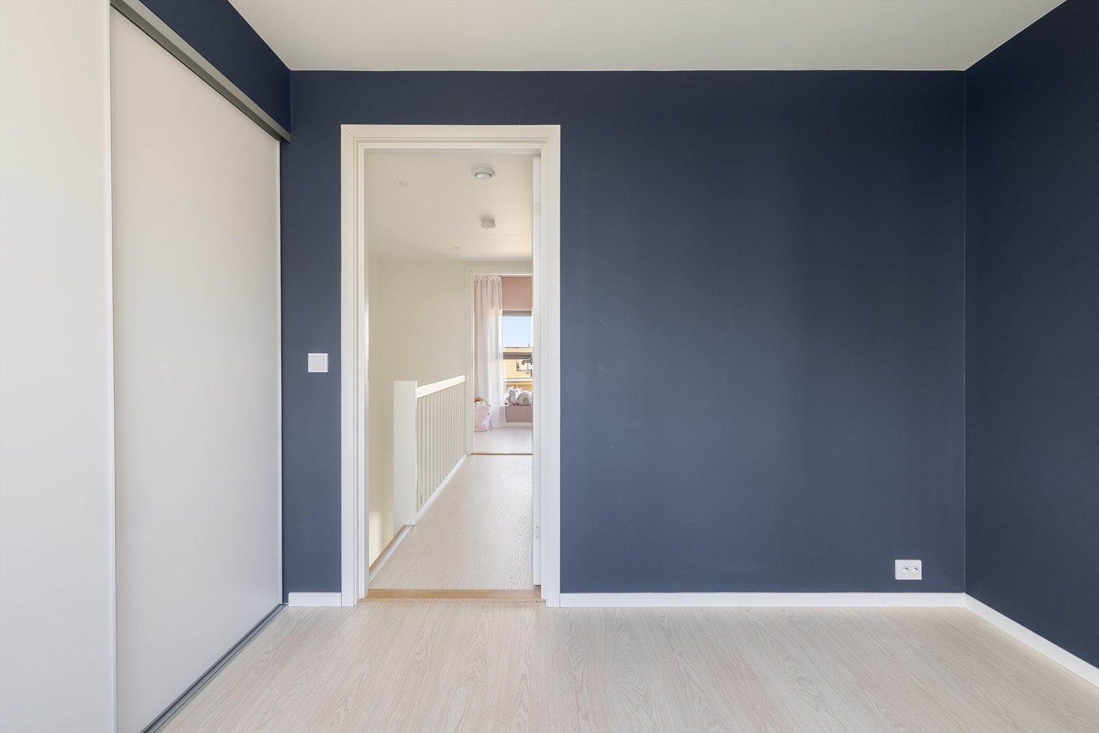 Det er satt inn en romslig skyvedørsgarderobe. Rommet er malt i en mørk blåfarge. Galleribilde