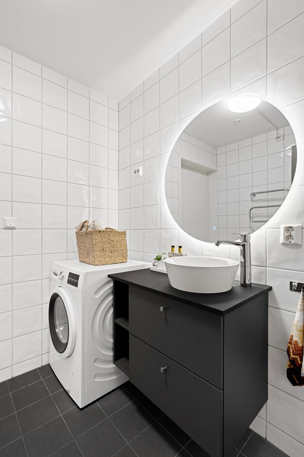 Badet har vegghengt toalett, dusjhjørne med foldbare glassvegger, speil med belysning og opplegg til vaskemaskin. God oppbevaringsplass i baderomsmøbel og ekstra skap. Vannbåren varme i gulv som gir økt komfort i hverdagen. Galleribilde