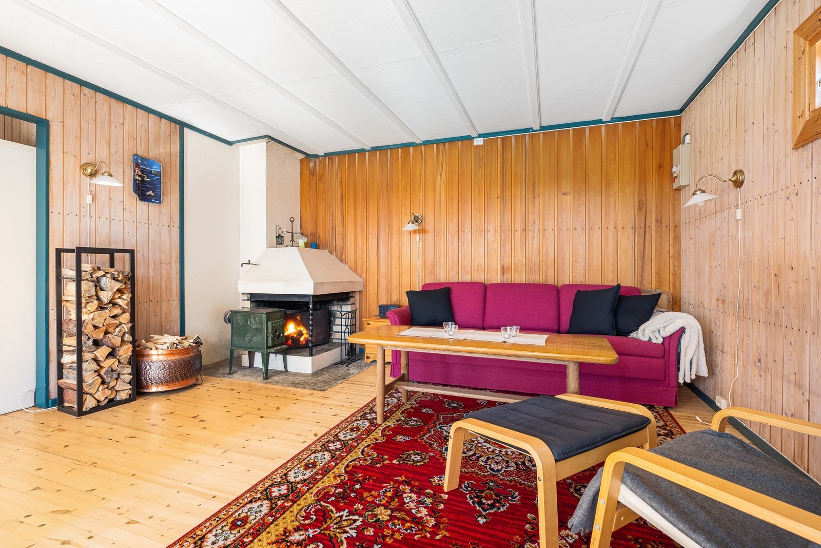 Del av stuen med peis og vedovn Galleribilde