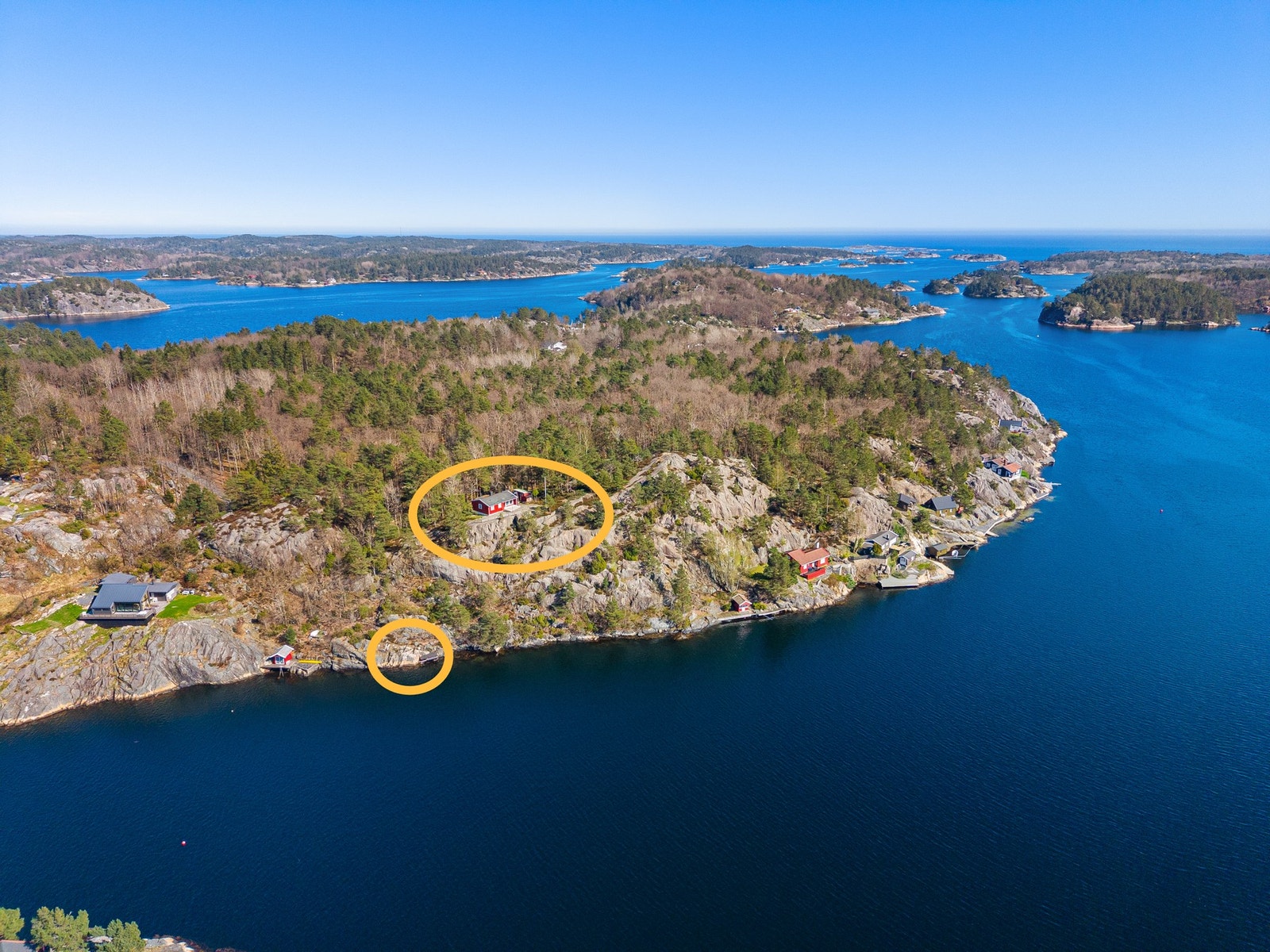 Dronebilde over området med hytten og bryggen ringet inn med gult Galleribilde