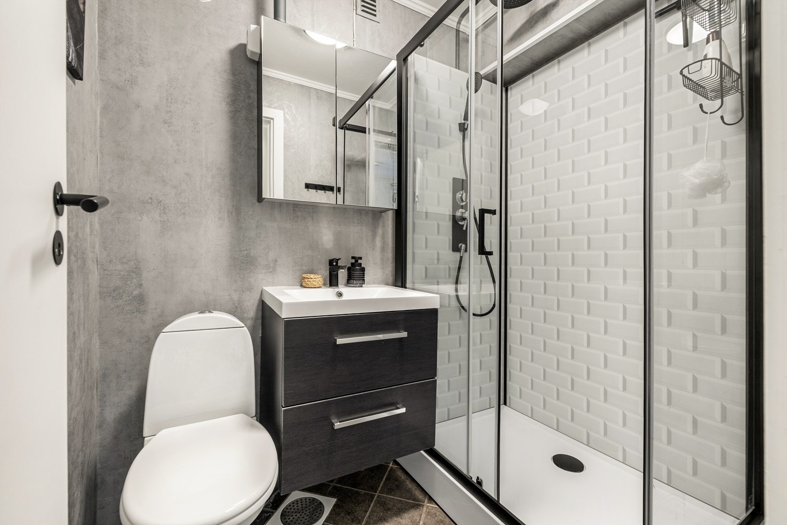 Videre har badet speilskap, dusjkabinett med glassdører og gulvmontert wc. Galleribilde