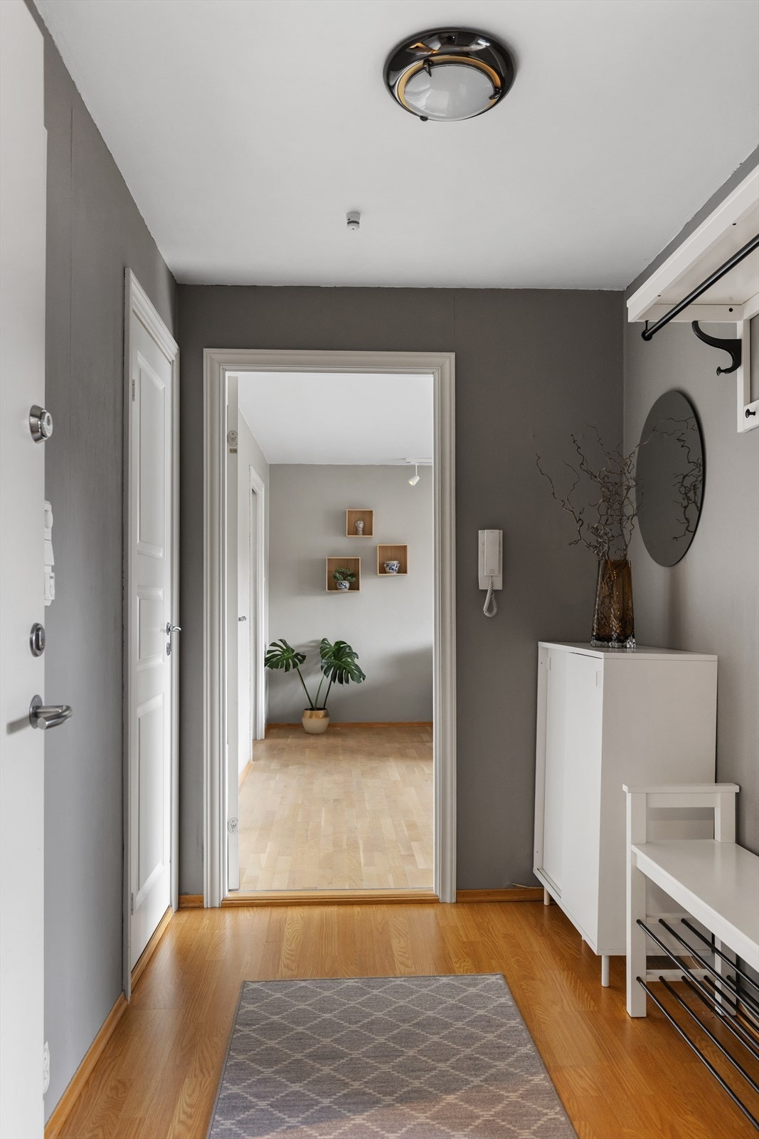 En lys og innbydende entré med plass til oppbevaring av yttertøy og sko. Dørcalling med portåpner gir enkel og trygg adkomst for deg og dine gjester. Galleribilde