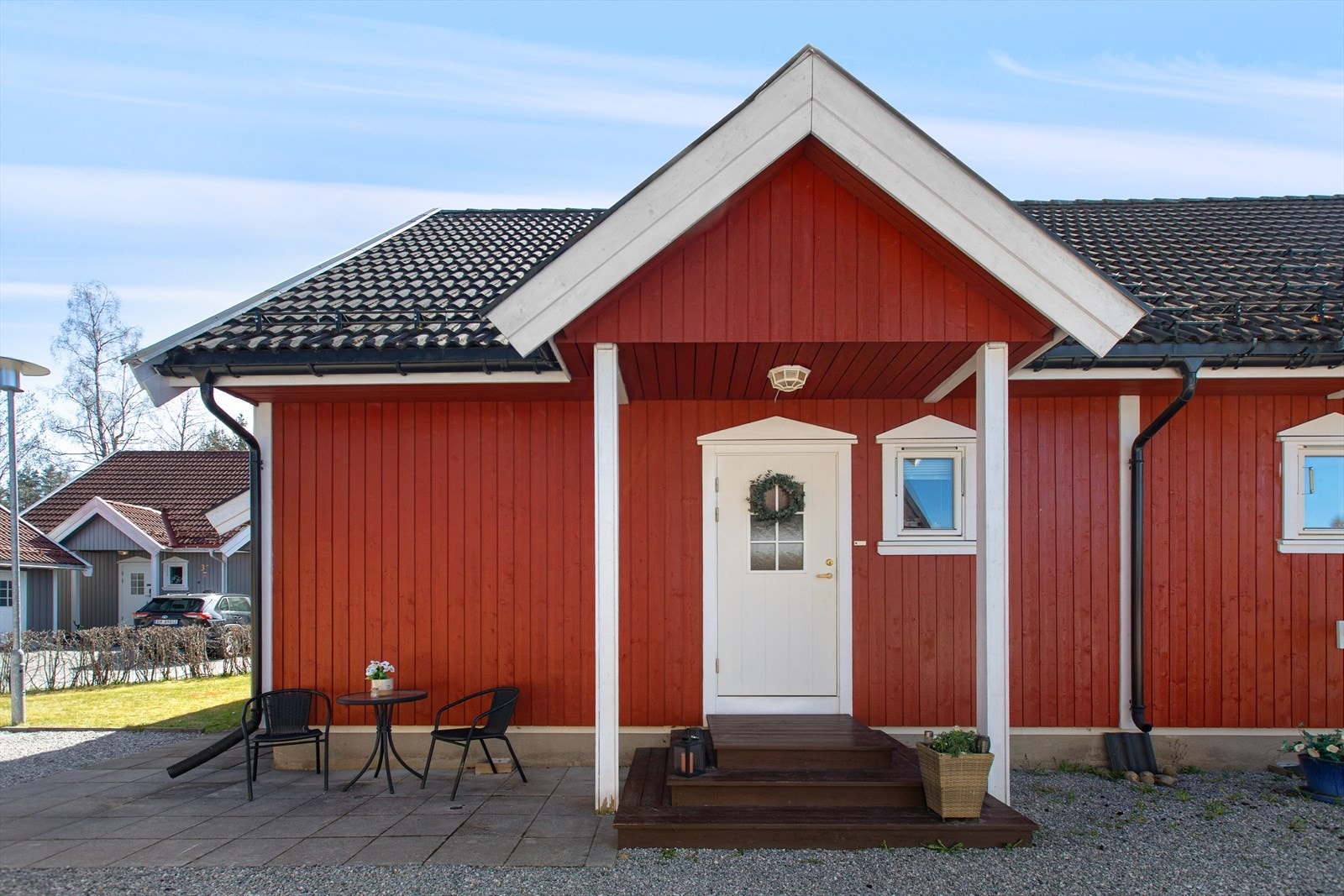 Boligen har en klassisk rød fasade med stående trekledning og hvite detaljer. Galleribilde