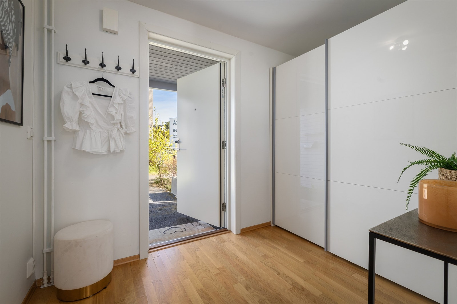Romslig entrè med god plass til yttertøy og sko i skyvedørsgarderobe Galleribilde