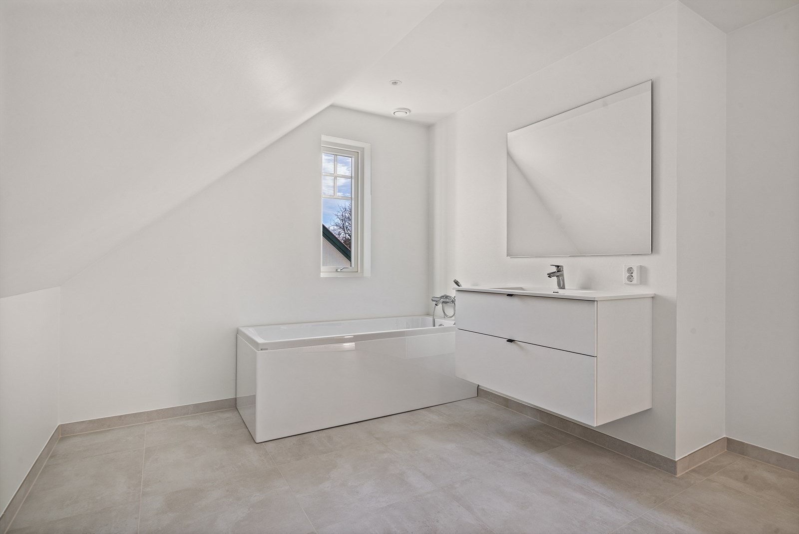Badet i andre etasje er malt i lyse farger og grå fine fliser på gulv. For øvrig inneholder badet badekar, toalett og servant. Galleribilde