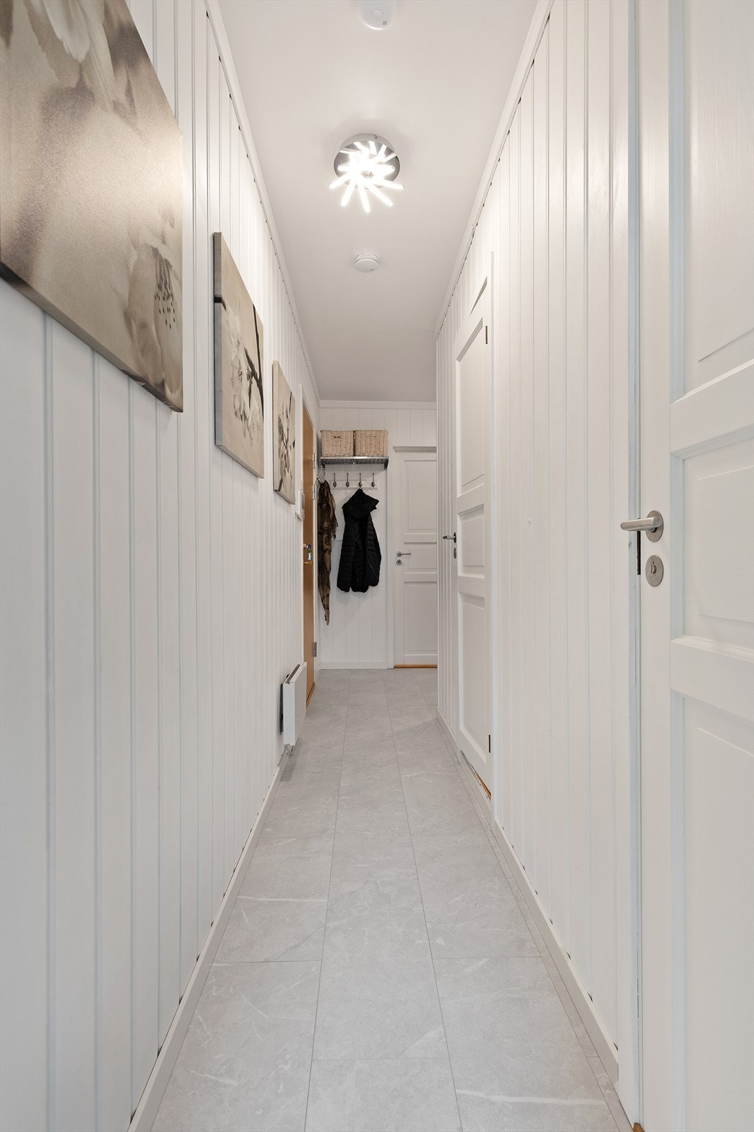 Den lange gangen har malte fyllingsdører og binder leilighetens rom sammen. Galleribilde