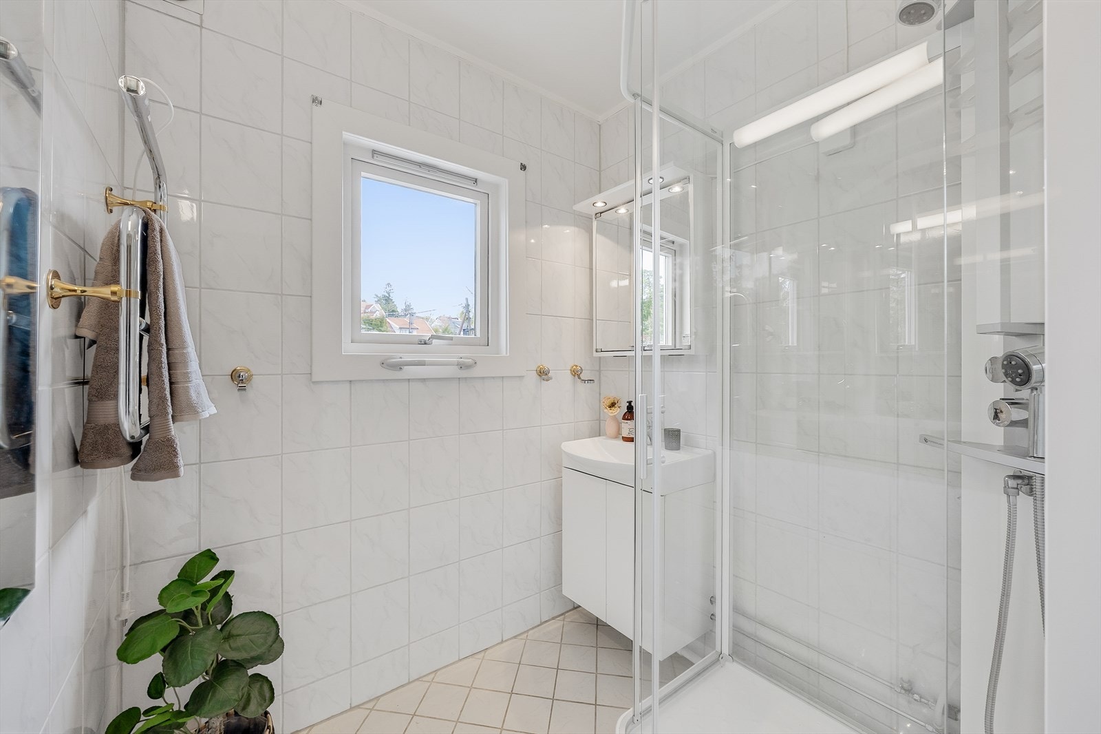 Badet har flislagt gulv med varmekabler og flislagte vegger. Badet er av eldre dato, og må påregnes totalrenovering. Galleribilde