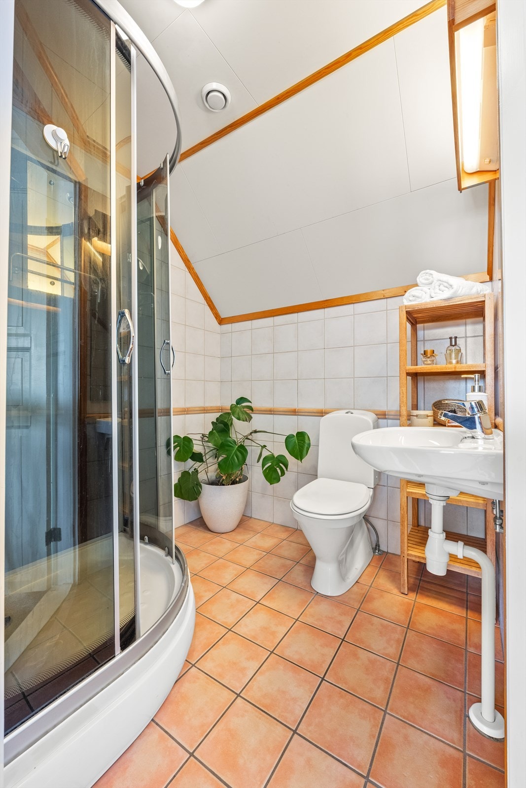 Badet på loftet har flislagt gulv med varmekabler, dusjkabinett og toalett. Galleribilde