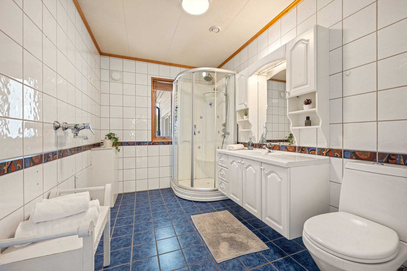 Badet i første etasje er helfliset og utstyrt med varmekabler, dusjkabinett og servantinnredning. Galleribilde