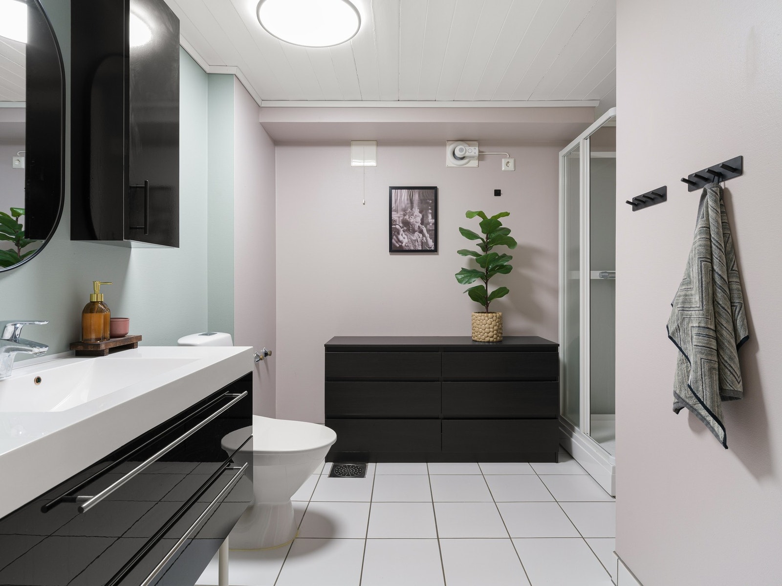 Badet er innredet med servantskap, veggskap og speil. Videre er rommet utstyrt med toalett og dusjkabinett. Galleribilde