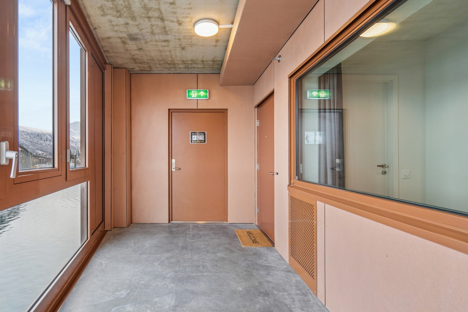 Inngangen til leiligheten ligger innerst i en felles svalgang med fantastisk sjøutsikt. Galleribilde