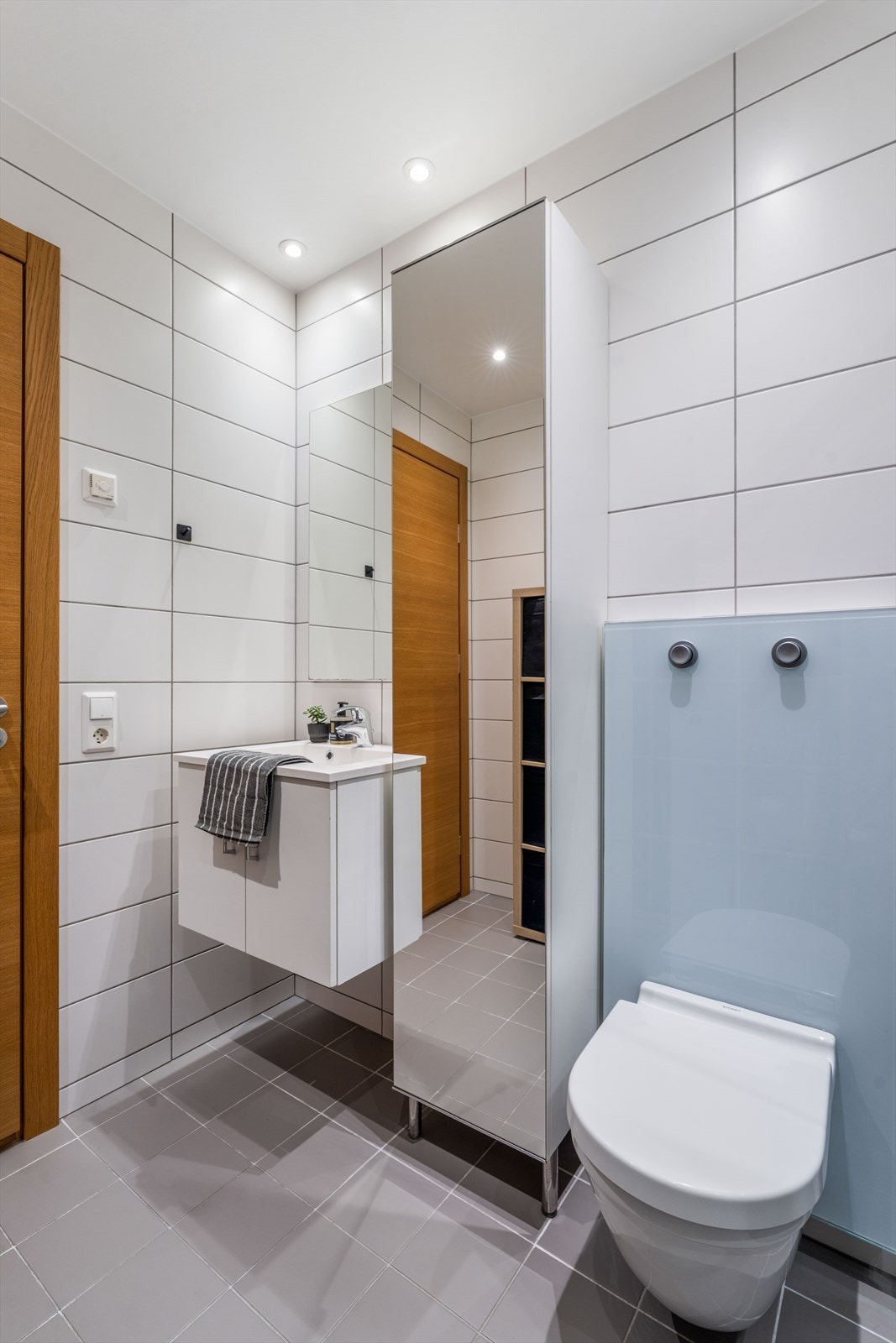 Badet er videre utstyrt med vegghengt servantinnredning og toalett, dusjhjørne og opplegg for vaskemaskin. Galleribilde