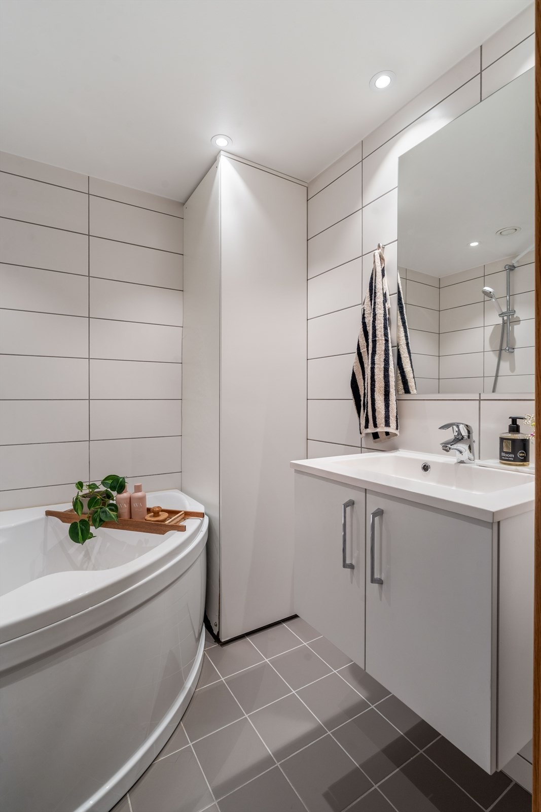 Badet er utstyrt med vegghengt servantinnredning, vegghengt toalett og badekar. Galleribilde