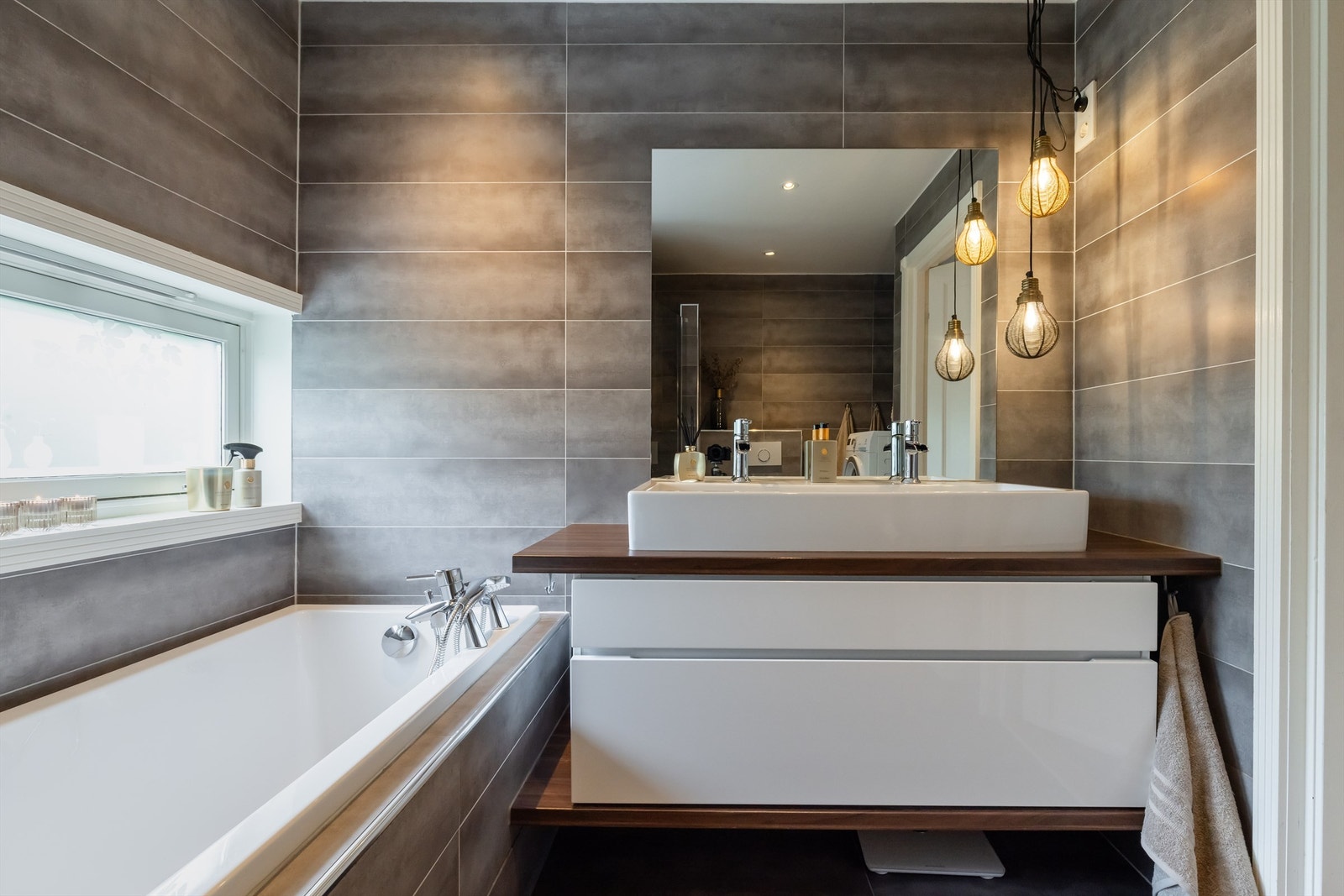 Badet er pent flislagt på gulv og vegger. Varme i gulvet sørger for en behagelig start på dagen. Galleribilde