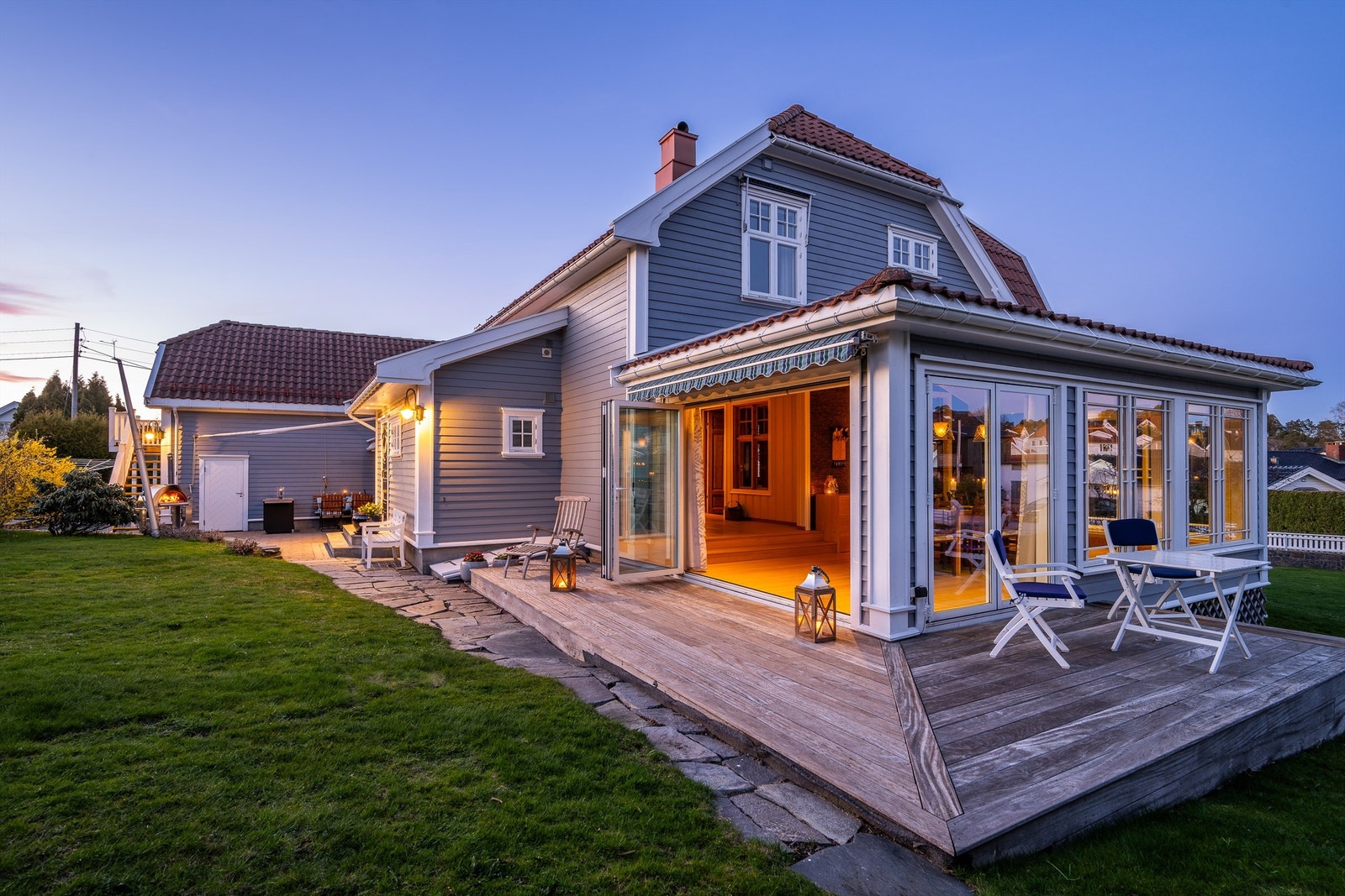 Spisestuen åpner boligen mot hagen med store foldedøre. Herfra er det utgang til en treterrasse på 25 m², som skaper en flytende overgang mellom inne- og uterom. Galleribilde