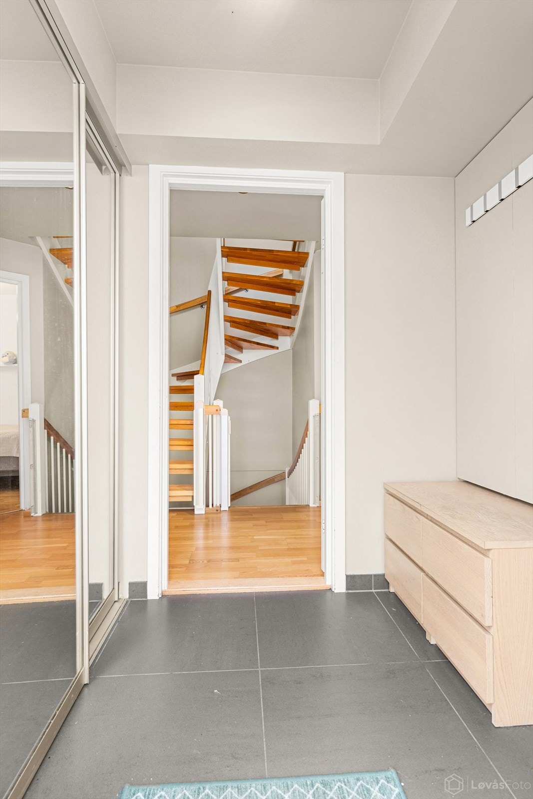 Innbydende, flislagt entré med praktisk skyvedørsgarderobe. Galleribilde