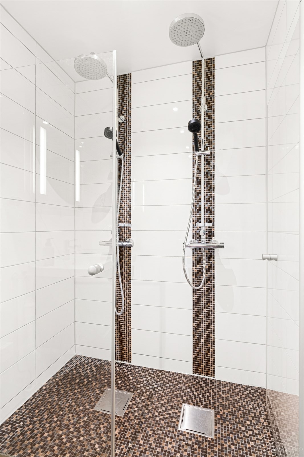 Badet består av dobbel regnfallsdusj, vegghengt toalett og servant med skuffer. Galleribilde