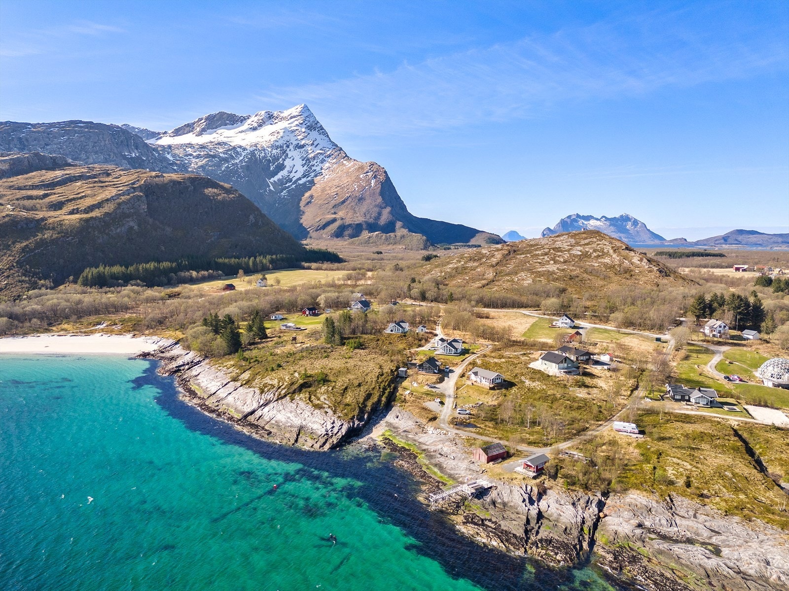 Her ser man det unike samspillet mellom det asurblå havet, den hvite stranden og de mektige fjellene. Galleribilde