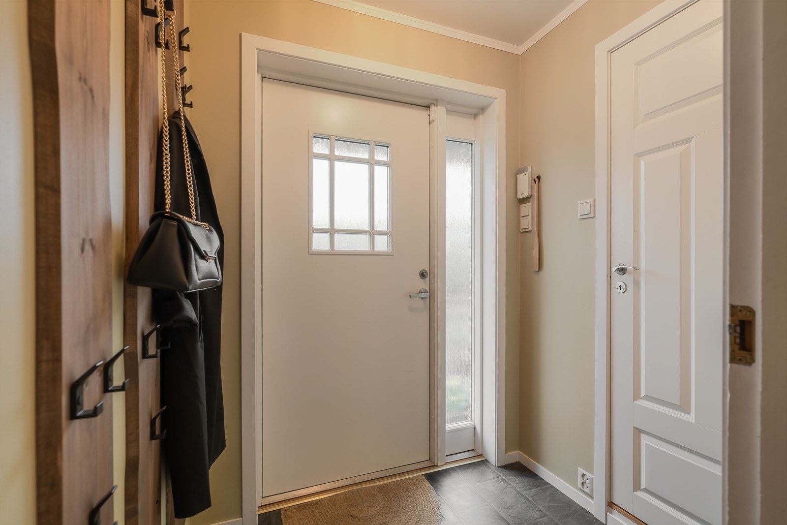 Velkommen inn i boligen via en hyggelig entré som leder deg videre inn i en romslig og innbydende gang. Galleribilde