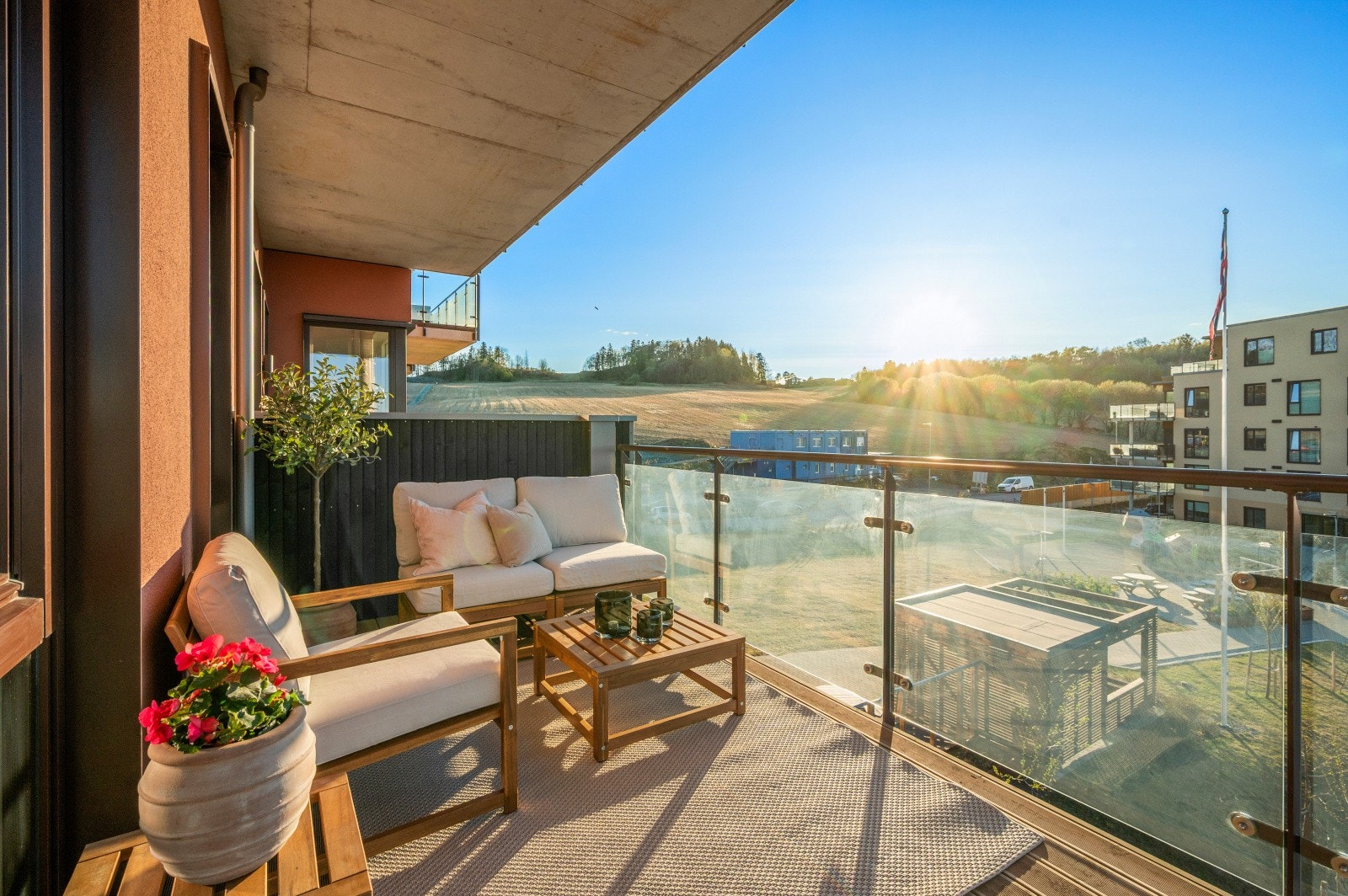 Gulvet er belagt med terrassebord i tre, og rekkverket er i glass og metall. Galleribilde