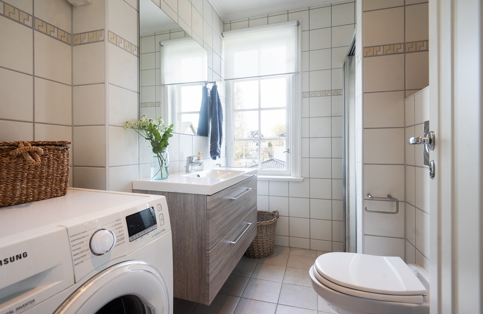 Flislagt bad med downlights og opplegg for vaskemaskin Galleribilde