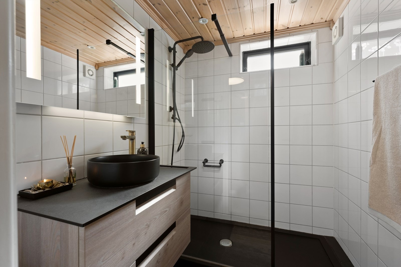 Badet har flislagte gulv og vegger. Himlingen er panelt og utstyrt med downlights. Badet har også varmekabler i gulvet. Galleribilde